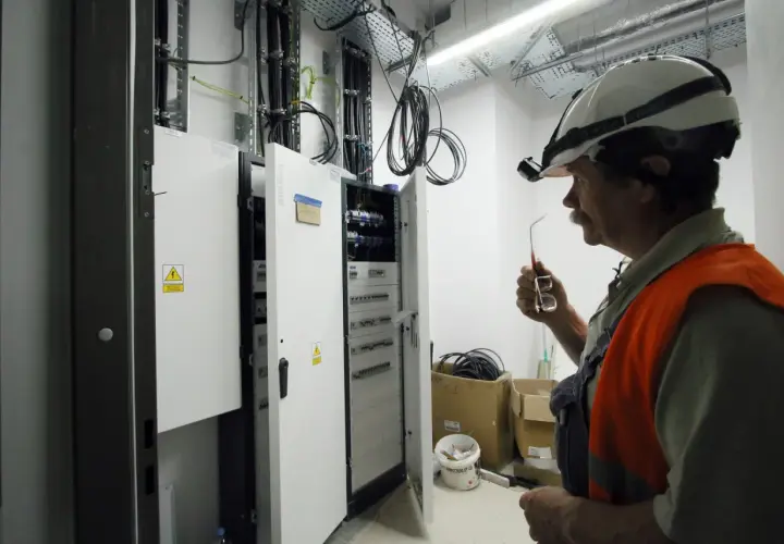 Inżynier elektryk w Niemczech, pracujący przy rozdzielnicy, zastanawia się, ile zarabia.
