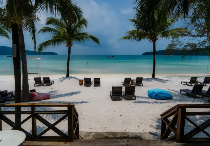 Rajska plaża na Koh Rong, Kambodża. Palmy, leżaki i turkusowa woda zapraszają do relaksu.