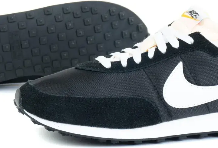 Czarne buty sportowe Nike z białym logo i sznurówkami. To pierwsze buty Nike, które zapoczątkowały legendę.