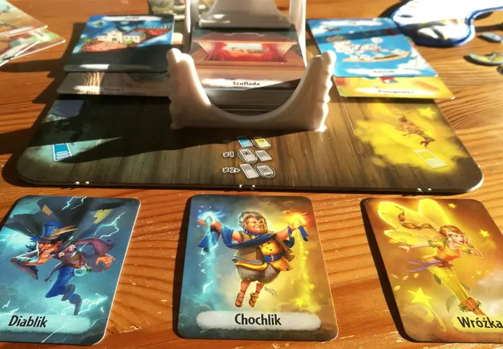 Kraina snów gra: Diablik, Chochlik i Wróżka na stole. Karty i plansza tworzą magiczny świat.