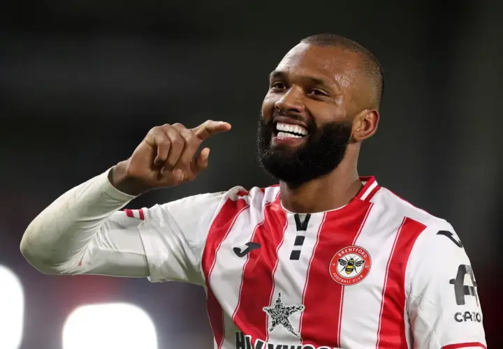 Uśmiechnięty Igor Thiago, piłkarz Brentford FC, pokazuje palcem w górę.