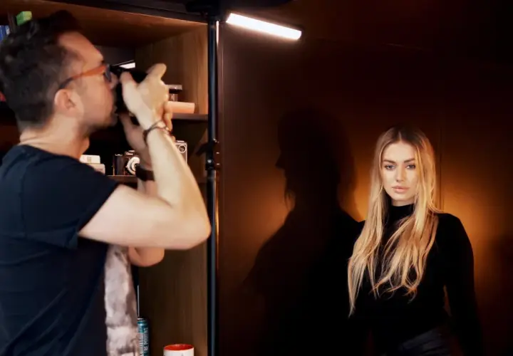 Fotograf robi zdjęcie modelce, tworząc idealne podświetlenie obrazu.
