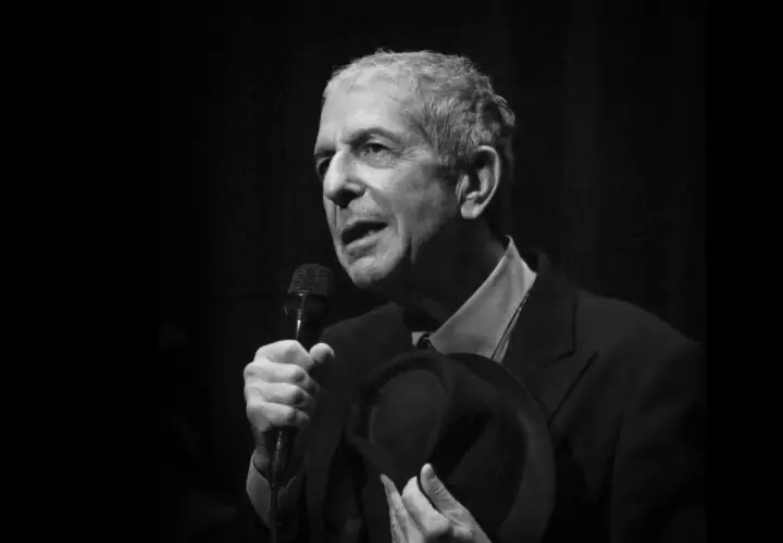 Leonard Cohen, z mikrofonem i kapeluszem w dłoni, śpiewa swoje ponadczasowe utwory.