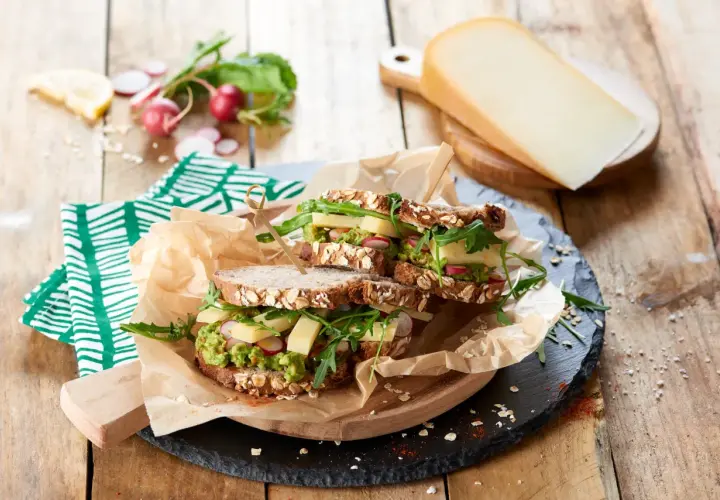 Une idée de sandwich gourmande : pain aux céréales, avocat, fromage, radis et roquette. Parfait pour un repas sain et savoureux.
