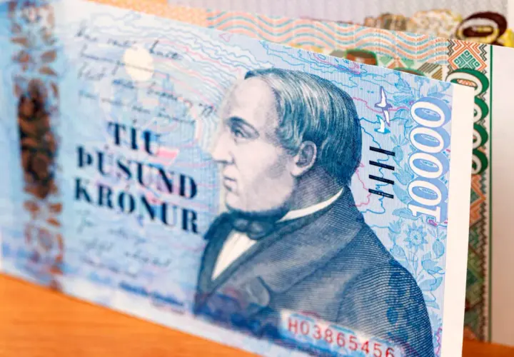 Fragment banknotu 10 000 koron islandzkich. Widoczny portret mężczyzny i cyfra 10000.