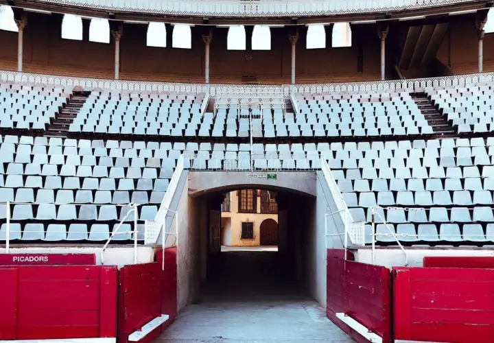 Tendidos vacíos en la plaza de toros de Las Ventas, con el plano de asientos visible y barreras rojas de picadores.