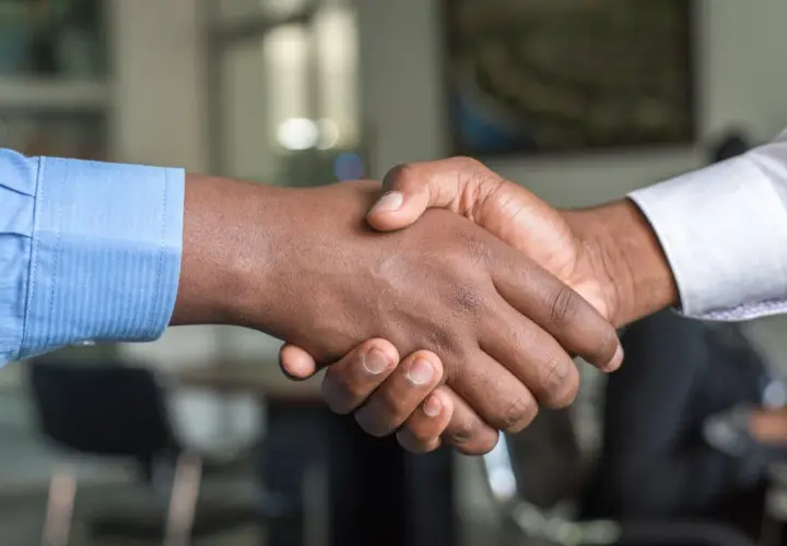 Dos hombres se dan la mano, sellando un acuerdo. Un apretón de manos que podría ser el inicio de un modelo precontrato exitoso.