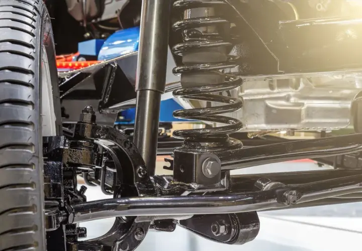 Detalle de la suspensión de un coche, con amortiguador y muelle helicoidal. Ideal para quienes buscan cambiar suspension coche.