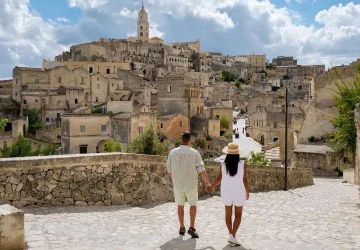 A couple walks through a historic Italian town, a perfect place to base yourself in Puglia.