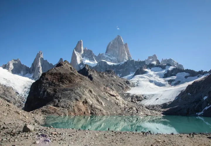 Majestätische Berge spiegeln sich in einem türkisfarbenen See. Die Szene vermittelt das Gefühl, dass dies die **Patagonien beste Reisezeit** ist, um diese atemberaubende Landschaft zu erleben.