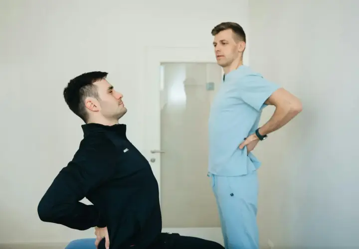Fizjoterapeuta ocenia plecy okrągłe pacjenta.
