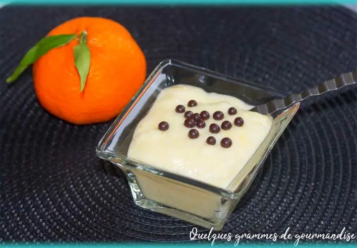 Mousse clémentine mascarpone légère et aérienne, décorée de perles de chocolat. Une clémentine fraîche à côté.