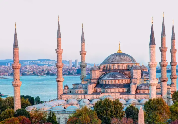 Impresionante mezquita con seis minaretes y cúpulas, bañada por la luz dorada del atardecer. Un paisaje de **estambul fotos bonitas** que te transporta a otra época.