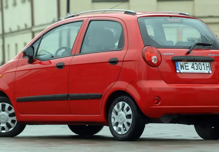Czerwony Chevrolet Matiz, model Spark, zaparkowany na ulicy.