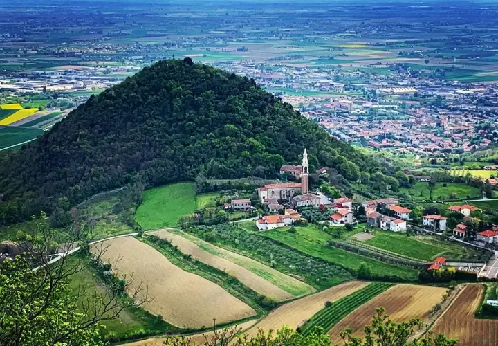 Panoramica dei Colli Euganei con un borgo e campi coltivati. Ideale per scoprire i ristoranti dei Colli Euganei.