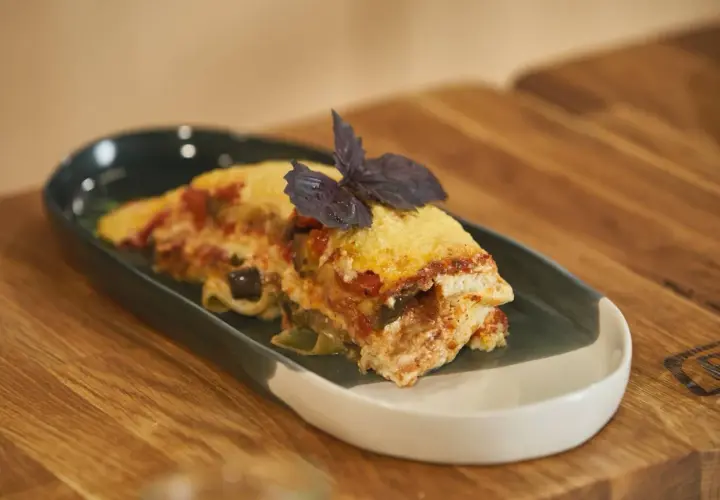 Pyszna lasagne z bakłażanem i pomidorami, udekorowana bazylią. Idealna, gdy zastanawiasz się, jak podgrzać lasagne w mikrofali.