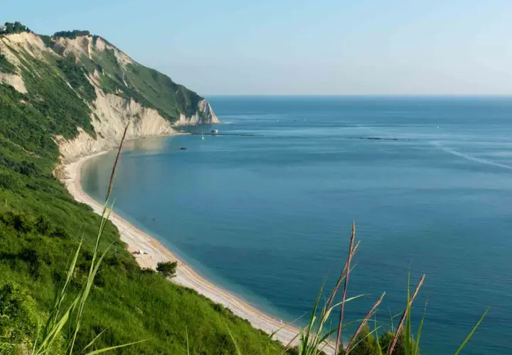 Vista panoramica della spiaggia di Mezzavalle, con scogliere verdi e mare azzurro. Le recensioni la descrivono come un paradiso.