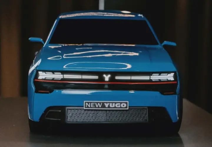 En blå, modern yugo bil med en Y-logotyp och texten "NEW YUGO" på fronten.