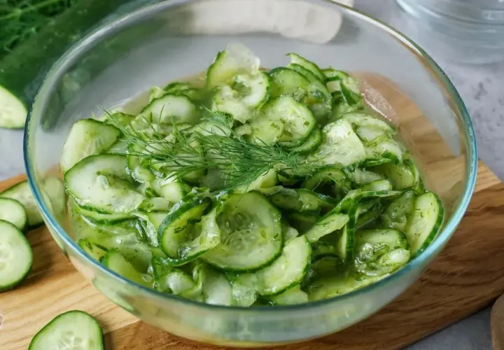 Frischer gurkensalat wie bei Oma, mit Dill garniert, in einer Glasschüssel.