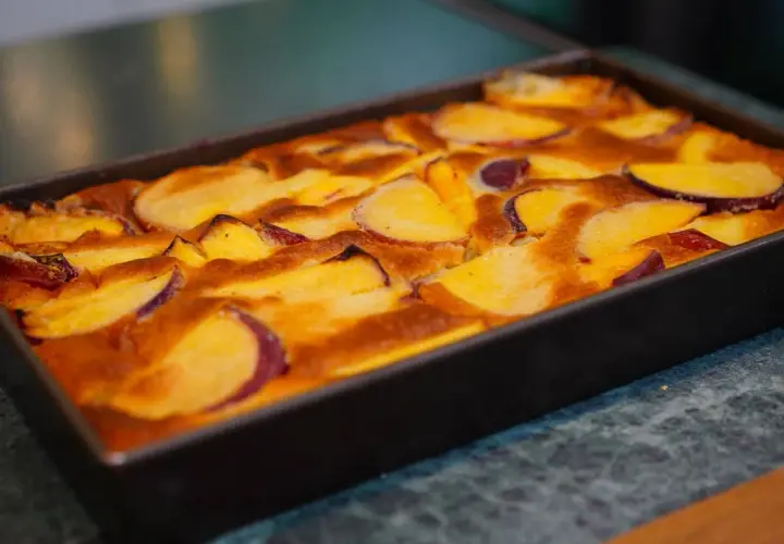 Clafoutis aux pêches dorées, tout juste sorti du four, prêt à être dégusté.