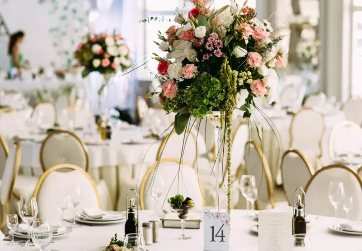 Elegancka dekoracja stołu weselnego z bukietem kwiatów i numerem 14. Sprawdź wedding planner cena, by zorganizować wymarzone przyjęcie.