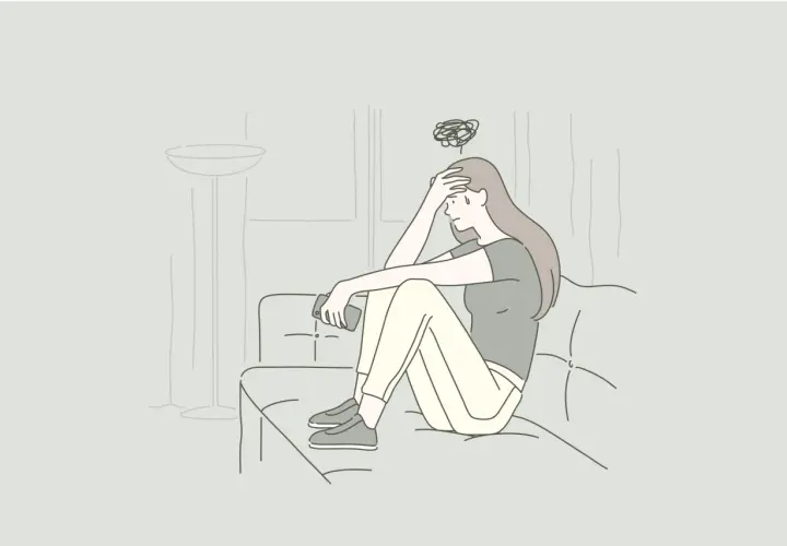 Ragazza seduta sul divano con la mano sulla fronte, pensieri confusi sopra la testa. Non voglio andare dallo psichiatra.