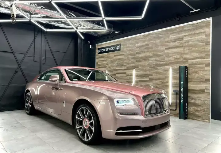 Luksusowy Rolls-Royce w różowym odcieniu, prezentujący efektowne oklejenia samochodu.