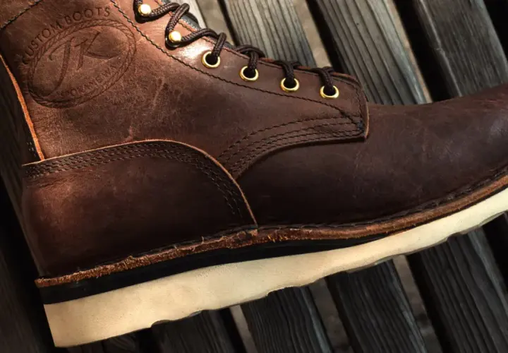 Brown leather boot with white sole. The stitching and laces are visible. This boot might make noise when you walk if the sole is loose.