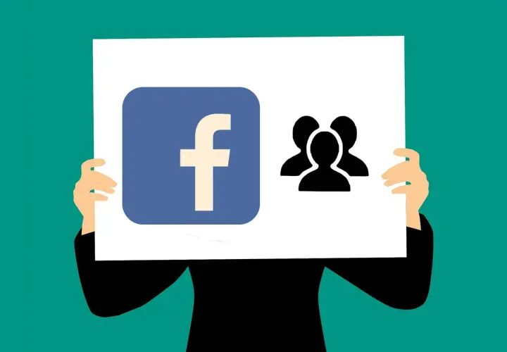 Logo Facebook i ikona grupy ludzi na plakacie. Ktoś trzyma go, prezentując się jako lider wśród fanów.