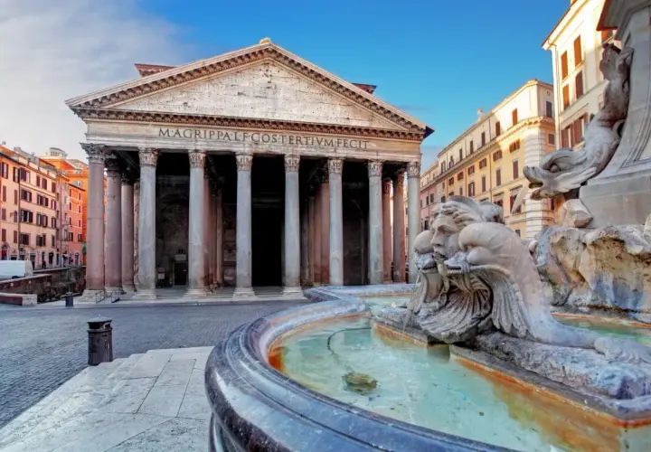 Fontana di Piazza della Rotonda Pantheon, con le sue sculture di delfini e volti, riflette la maestosità dell'edificio antico.