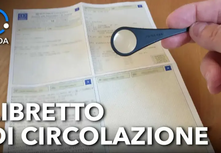 Guida per trovare il codice OEM sul libretto di circolazione. Lente d'ingrandimento su un documento.