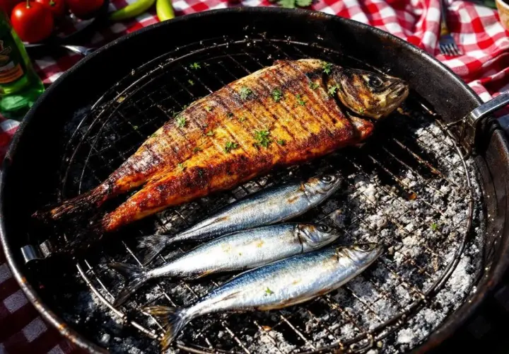 Poisson grillé et sardines sur un barbecue. Faut-il écailler les sardines avant de les griller ? La réponse est dans l'image.