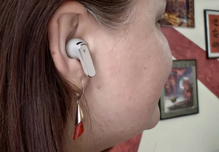 Ucho z białą słuchawką Huawei. Dowiedz się, jak podłączyć słuchawki Huawei do iPhone, by cieszyć się muzyką.