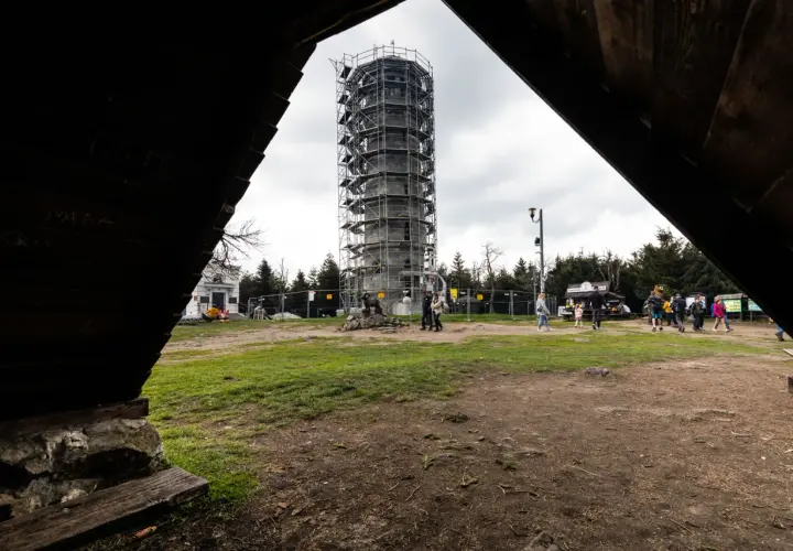 Wielka Sowa szlaki turystyczne prowadzą do wieży widokowej w rusztowaniach. Ludzie spacerują po placu.