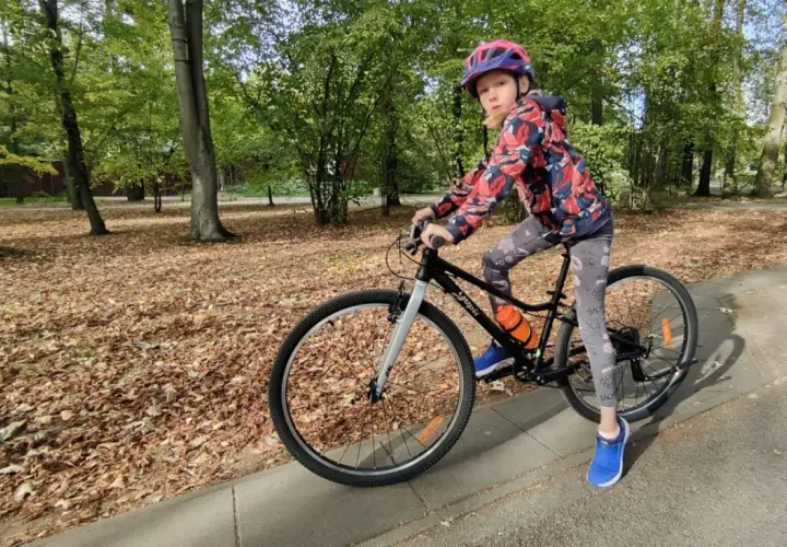 Dziewczynka na rowerze, idealny rower dla 10 latka ile cali? W parku jesienią.