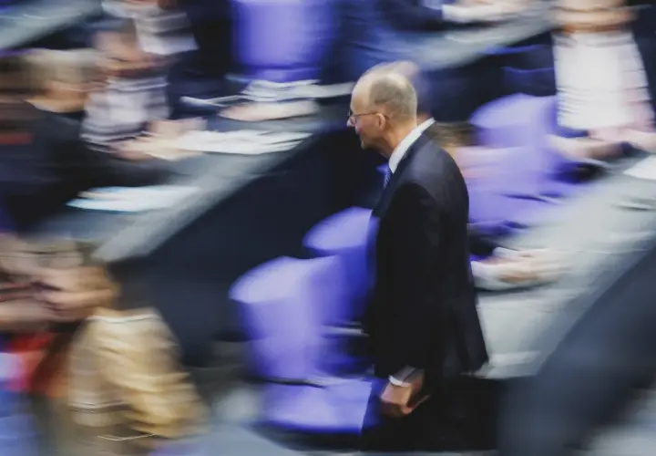 Mann im Anzug geht durch den Bundestag. Wer darf Bundeskanzler werden? Die Frage beschäftigt viele.