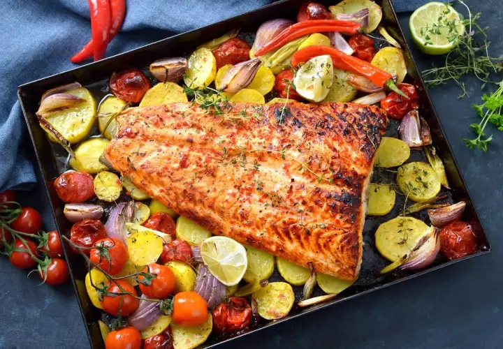 Delicioso pescado al horno con patatas, tomates, cebolla y pimientos. Un plato completo y sabroso.