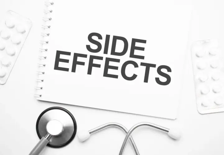 Notatka z napisem "SIDE EFFECTS" obok stetoskopu i blistrów z tabletkami. Czy NAC suplement ma skutki uboczne?