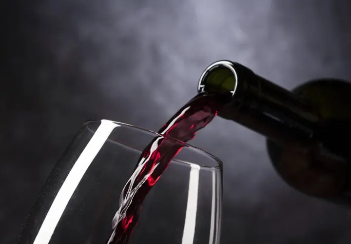 Ciemnoczerwone, bogate montalcino wino leje się z butelki do kieliszka, tworząc kaskadę smaku.
