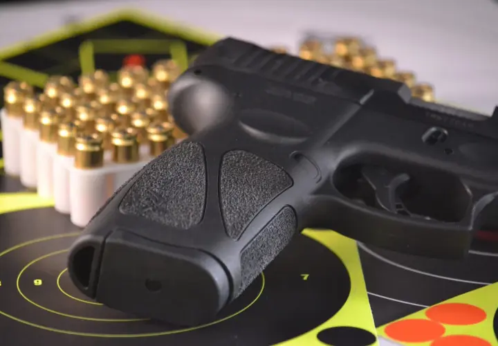 Pistolet i amunicja na tarczach strzeleckich, symbolizujące pozwolenie na broń do ochrony osobistej.