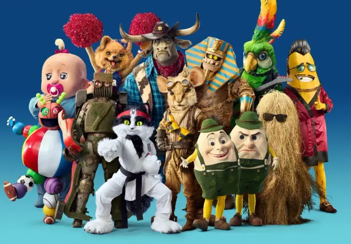 En grupp fantasifulla karaktärer, som från Masked Singer Sverige, poserar framför en blå bakgrund.