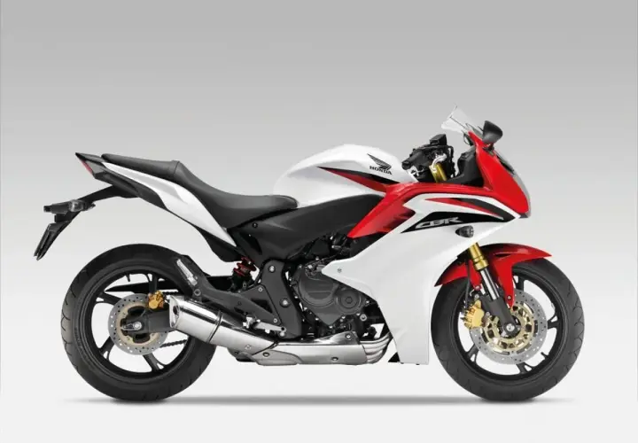Sportowy motocykl Honda CBR600F w białej i czerwonej kolorystyce, gotowy do dynamicznej jazdy.