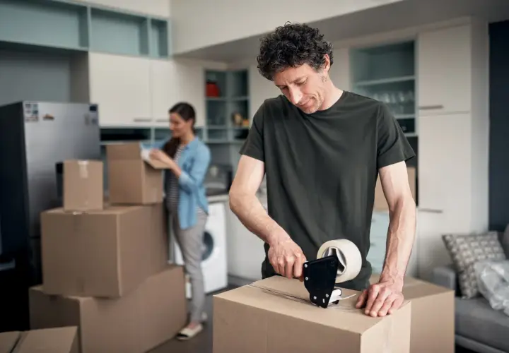 Mann packt Kartons für den Umzug. Bald wird er die umzugskosten steuerlich absetzen können.