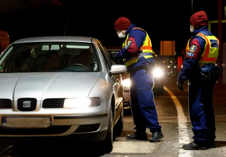 Policjanci w kamizelkach odblaskowych kontrolują samochód. To część działań związanych z imi delegowanie kierowców.
