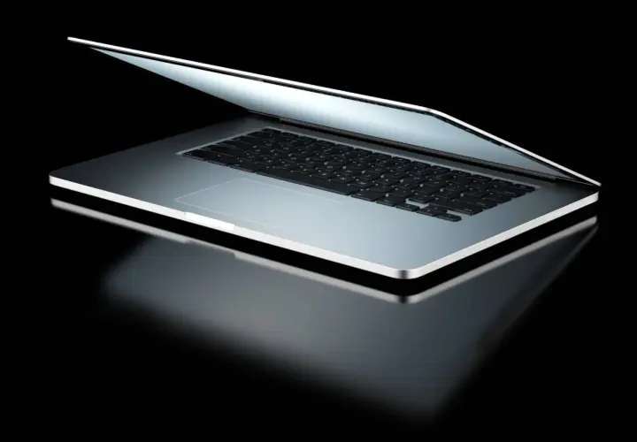 Elegancki laptop z otwartą klapą, odbijający światło. Dowiedz się, jak sprawdzić model laptopa, by poznać jego specyfikację.
