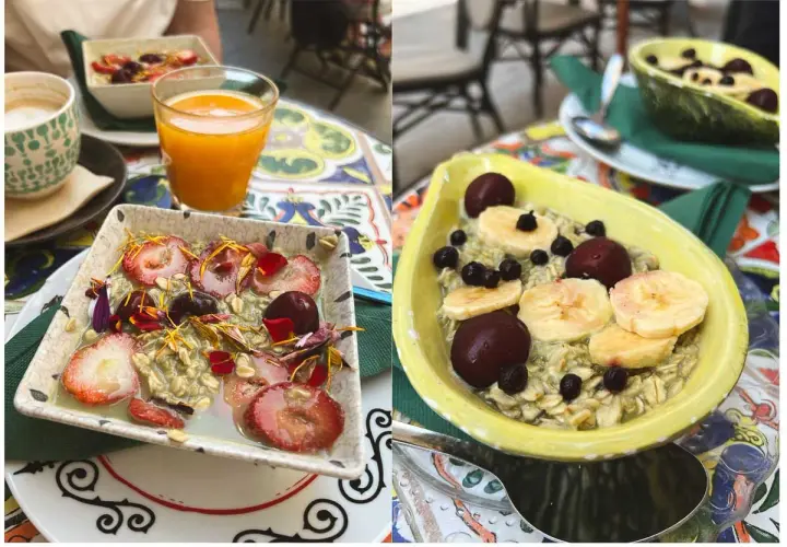 Zwei Schalen mit leckerem Matcha Porridge, garniert mit Erdbeeren, Kirschen und Bananenscheiben. Ein gesunder Start in den Tag!