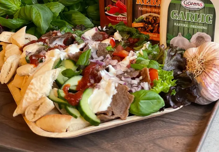 En läcker tallrik med iskender kebab, fylld med kött, grönsaker, bröd och såser. Perfekt för en smakrik måltid.
