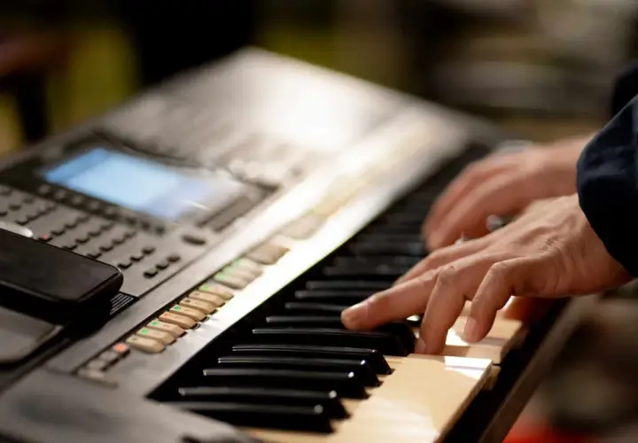 Dłonie grające na keyboardzie, tworząc muzykę. To jest keyboard.