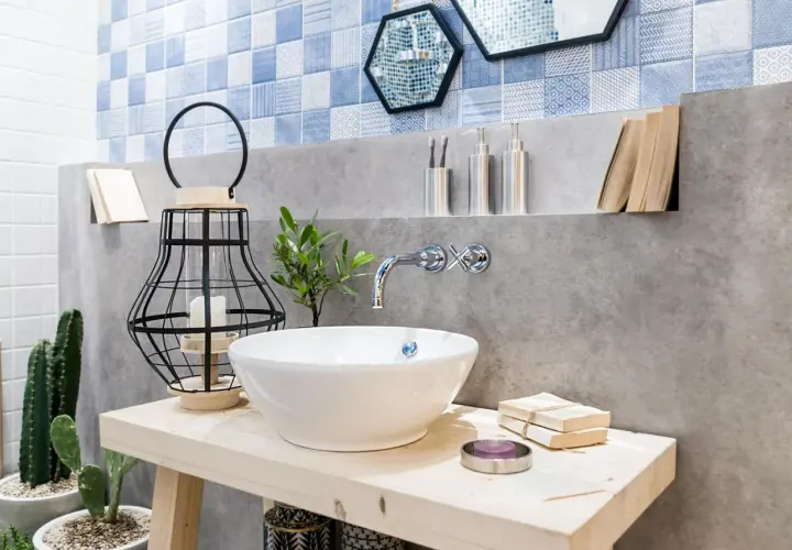 Bad Deko Ideen: Waschbecken mit Kaktus, Laterne und Büchern. Blaue Fliesen und Betonwand.