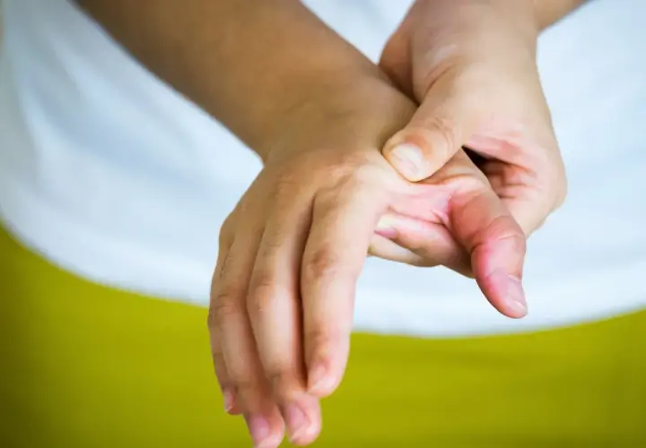 Mano con dolor en el pulgar, buscando alivio y soluciones sobre como curar la rizartrosis del pulgar.